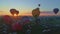 Aerial view of a morning launch of hot air balloons at a hot air balloon festival at sunrise on a sunny summer day