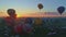 Aerial view of a morning launch of hot air balloons at a hot air balloon festival at sunrise on a sunny summer day