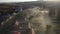 Aerial view of morning mist above a village. House roofs raising from clouds