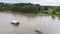 Aerial view of motor boat pulling raft house in river with mountain and sky view. landscape of floating hotel on river in Kanchana