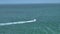 Aerial view of motorboat sailing fast on sea waves with ripple surface. Sailboat in motion on ocean in Florida