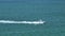 Aerial view of motorboat sailing fast on sea waves with ripple surface. Sailboat in motion on ocean in Florida