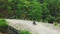 Aerial view of a motorcycle rider driving bike along a bridge in countryside.