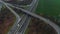 Aerial view of a motorway. Static camera with view on cars running on the highway and the road. A lot of vehicles ride on the four