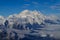 Aerial view of Mount Denali - mt Mckinley peak from a plane with glaciers around and blue sky above. Denali National