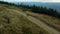 Aerial view mountain biking on hilly grassy road against blue sky enjoying