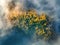 Aerial view of mountain forest in low clouds at sunrise in autumn