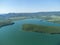 Aerial view on mountain lake. Drone over water reservoir at mountain valley covered with green spring forest. Beautiful