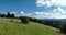 Aerial view of mountain peaks and fresh green grass on a sunny summer day