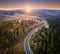 Aerial view of mountain road in forest at sunset in autumn