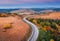 Aerial view of mountain road in forest at sunset in autumn