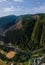 Aerial view of mountain road, mountains and a river near the town of Predazzo, Trentino, Italy consequences of bad weather,