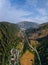 Aerial view of mountain road, mountains and a river near the town of Predazzo, Trentino, Italy consequences of bad weather,