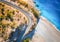 Aerial view of mountain road near blue sea with sandy beach