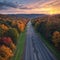 Aerial view of mountain road in village at sunset in autumn. Top view from drone of road in woods. Beautiful