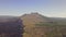 Aerial view of mountain slope with solidified lava flow partly burnt bushes.