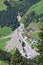 Aerial view of mountain stream in the Austrian Alps blocked after a massive mudflow with excavator and truck working to clean up