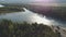 Aerial view of mouth of large river among dense forests at sunset in summer.