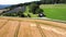 An aerial view of a mowed wheat field and a horse pasture in western Germany.