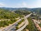 Aerial view of multiple lane highway crossing villages and forest hills Autostrada dei Fiori - A10 Liguria Italy