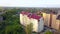 Aerial view of multistory apartment building in green residential area.