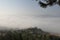 Aerial view of a mysterious foggy green forested hillside