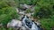 Aerial view narrow meandering river with small waterfall