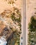 Aerial view of a narrow road with vehicles driving along the wild south coastline facing the Atlantic Ocean wit crispy waves