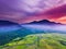 Aerial View natural beauty of the mountain with dense forests and green rice fields, morning sun with incredible sky i