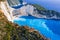 Aerial view of Navagio Beach - Shipwreck beach - on Zakynthos Island, Greece. Tourists on cliff edge enjoy view on