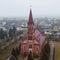 Aerial view neogothic red catholic church of the Heart Jesus in small Belarusian village Stolovichi