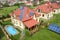 Aerial view of a new autonomous house with solar panels and water heating radiators on the roof and green yard with blue swimming