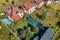 Aerial view of a new autonomous house with solar panels, water heating radiators on the roof, wind powered turbine and green yard