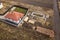 Aerial view of new house roof with attic windows and building site, foundation of future house, stacks of bricks and building