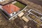 Aerial view of new house roof with attic windows and building site, foundation of future house, stacks of bricks and building