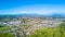 Aerial view on a New Plymouth residential suburb surrounded by green meadow with Mount Taranaki on the background. New Zealand