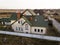 Aerial view of new residential house cottage and garage or barn with shingle roof on fenced yard on sunny day