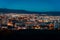 Aerial view, night cityscape view with night sky. natural clear view over big city blocks with street lights and hills around -