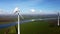 Aerial view of non-rotating wind turbines along a river in a Dutch landscape.