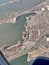 Aerial view of Oakland California Port and Alameda with container ships, forklifts, railroads and highways.