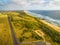 Aerial view of ocean coastline and straight rural highway in Australia.