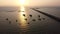 Aerial View of the Ocean at Sunset with a Pier and Boats near the Shore, A Long Pier Near the city