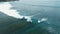 Aerial view of ocean with surfer ride on perfect wave in Bali