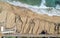 Aerial view of ocean waves breaking on a sandy beach. Beach erosion after coastal flooding.