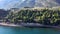 Aerial view ofshore with blue sea, road with trees and back mountain, Kamena Vourla Greecemoving forward