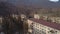 Aerial view of the old abandoned residential buildings surrounded by mountains with trees. Shot. Old settlement at the