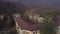 Aerial view of the old abandoned residential buildings surrounded by mountains with trees. Shot. Old settlement at the