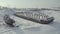 Aerial view of an old pier and a moored rusty ship on a snow covered shore. Clip. Winter landscape of an abandoned pier