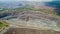 Aerial view of opencast mining quarry with lots of machinery at work.