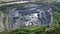 Aerial view of opencast mining quarry in the middle of the forest